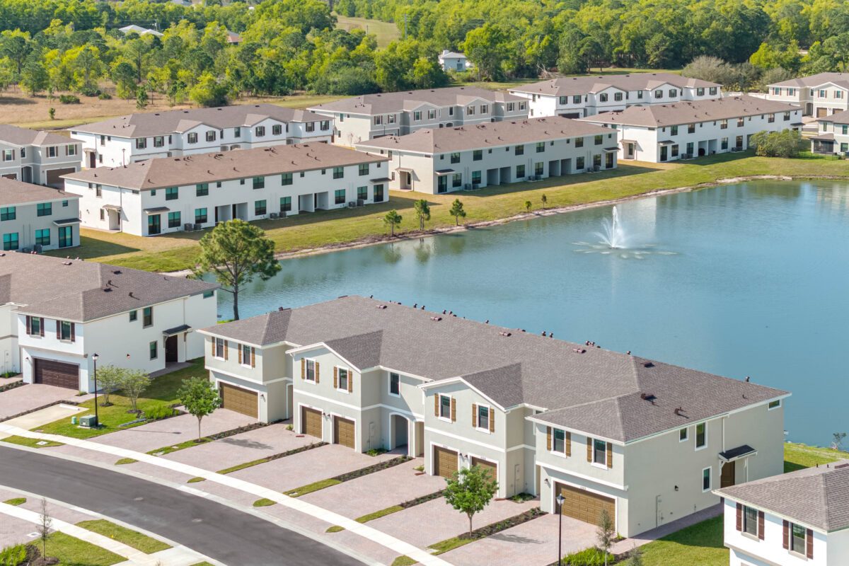 Aerial photo of a build-to-rent townhome community around a landscaped lake, Orlando, FL